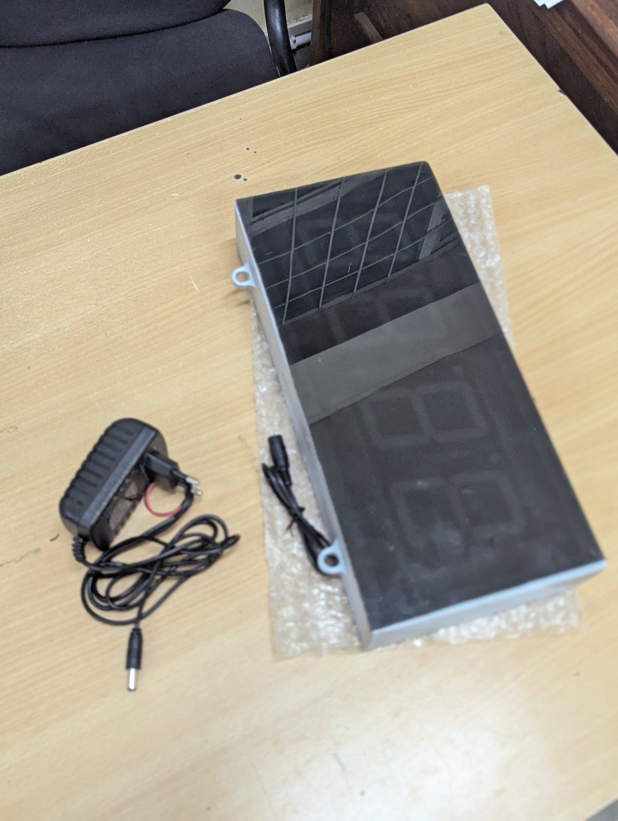 The custom digital clock unit and its power adaptor before installation